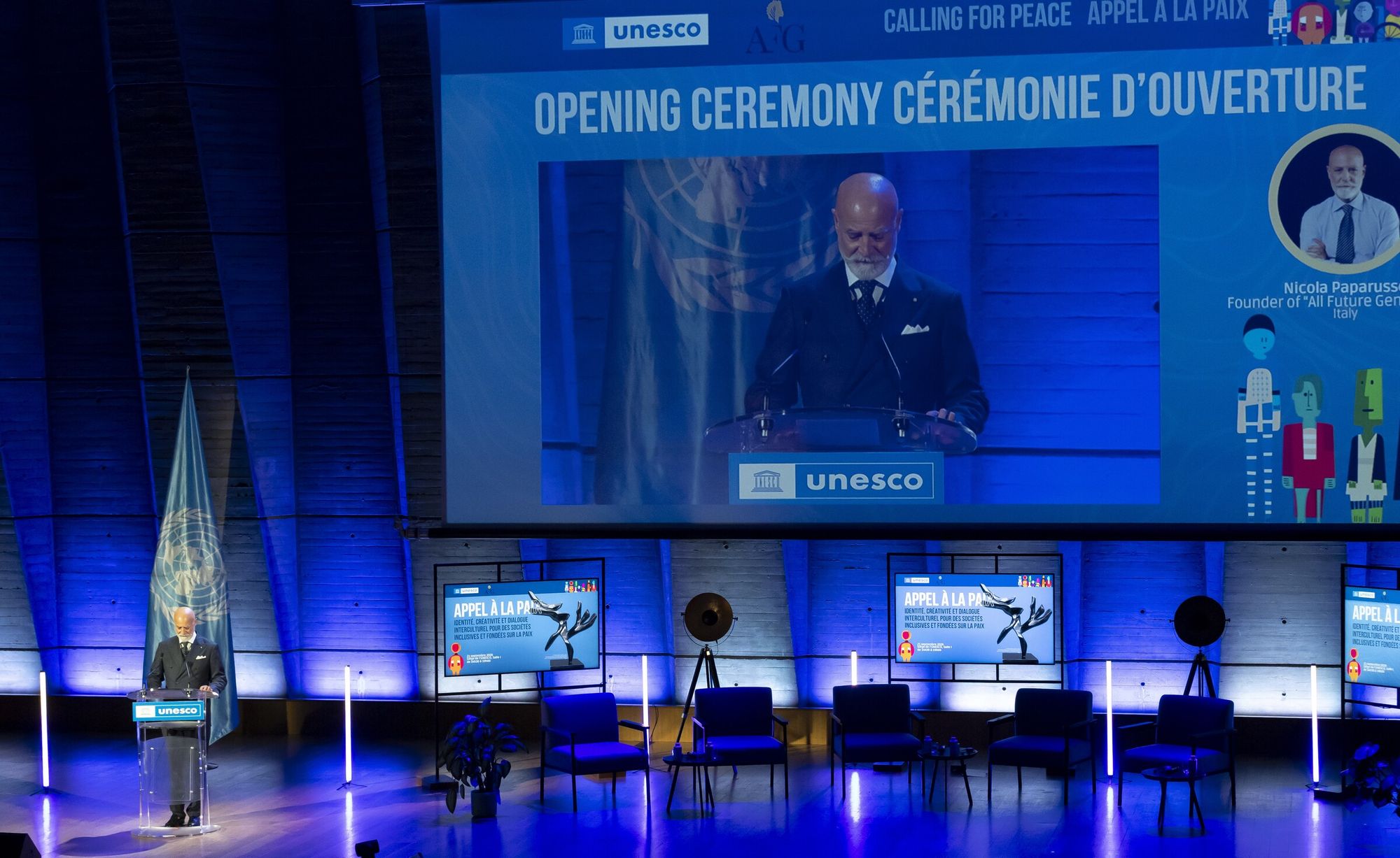 Cerimonia d'apertura di Calling for Peace nella sede UNESCO di Parigi: Nicola Paparusso, fondatore di AFG, parla dal podio e compare sul grande schermo del palco