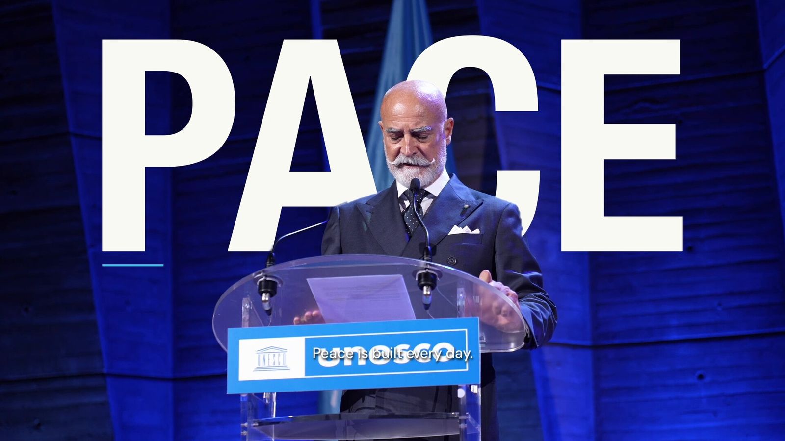 Nicola Paparusso on the UNESCO stage in front of the word PACE