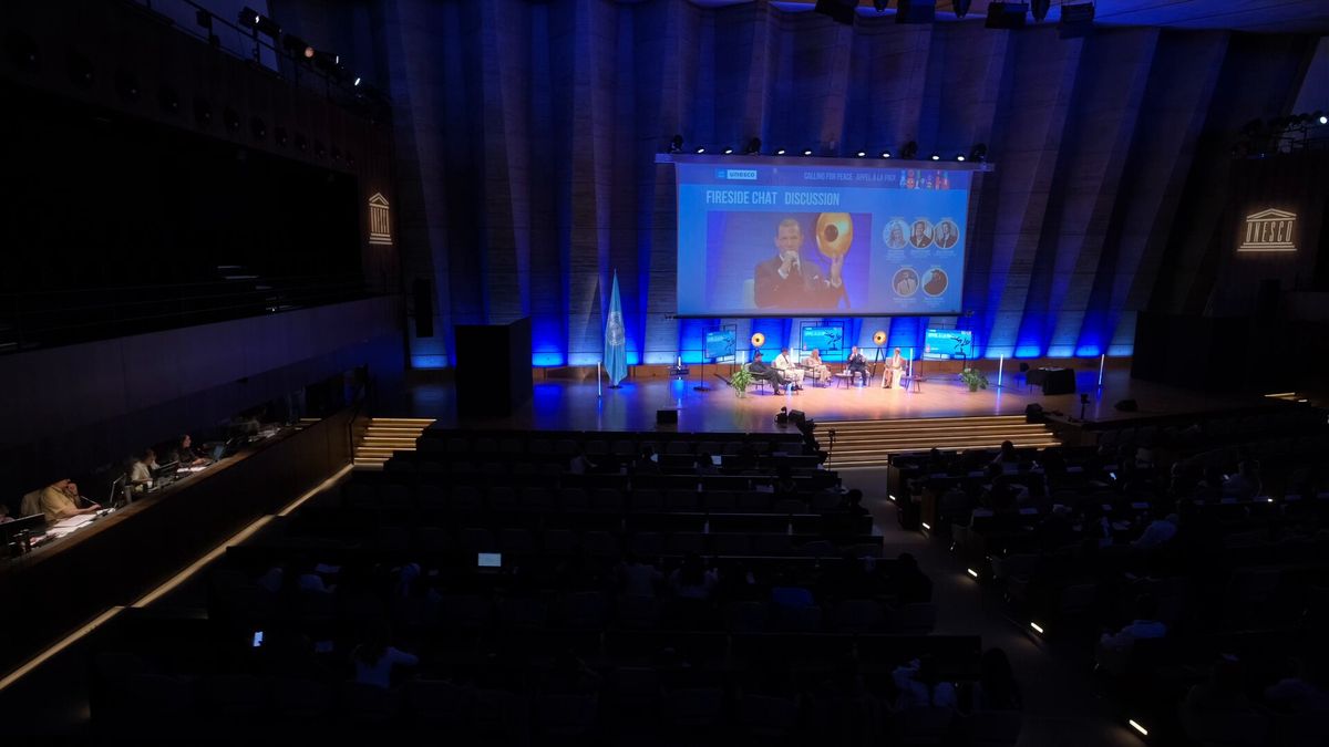 La sala vista dall'alto, con il palco illuminato di blu e il pubblico